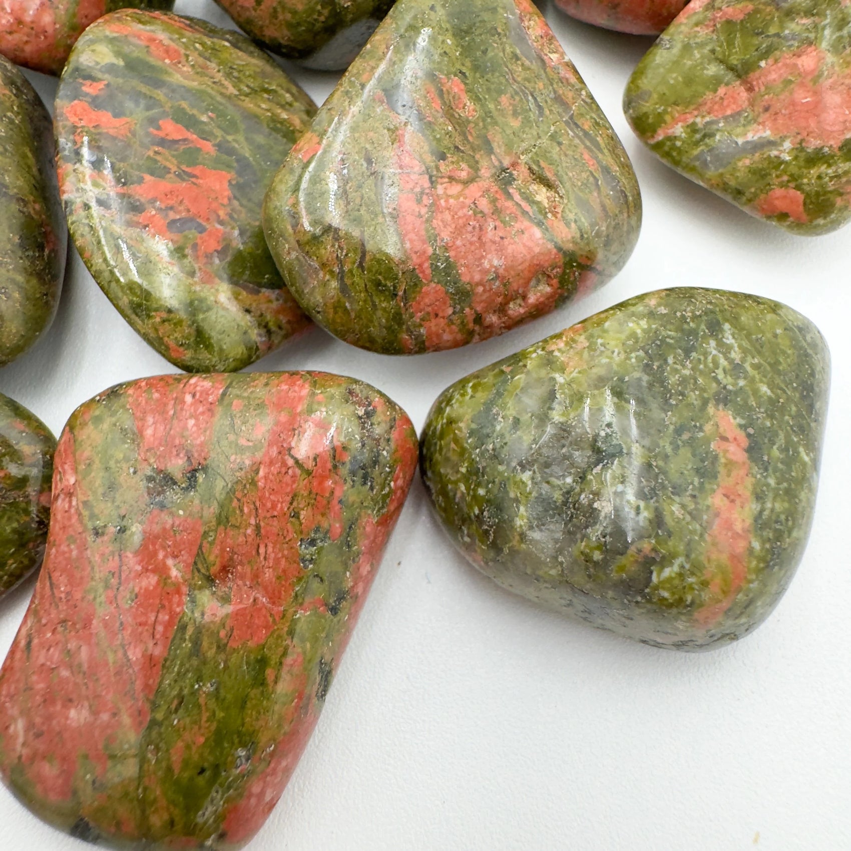 Overhead angle of Unakite tumbled stone, showing natural texture.
