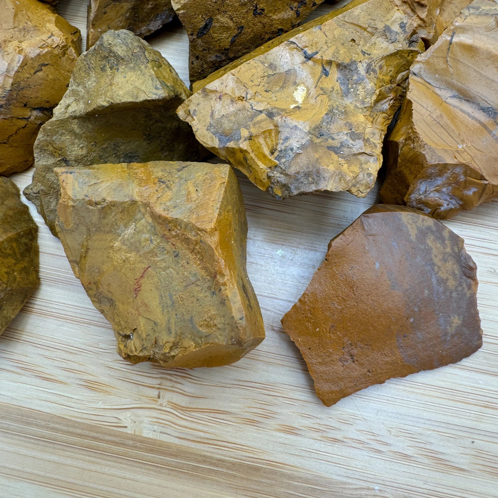 Edge view of Grade AA Yellow Jasper raw stone, sourced from Sofia, Madagascar, showing natural texture.