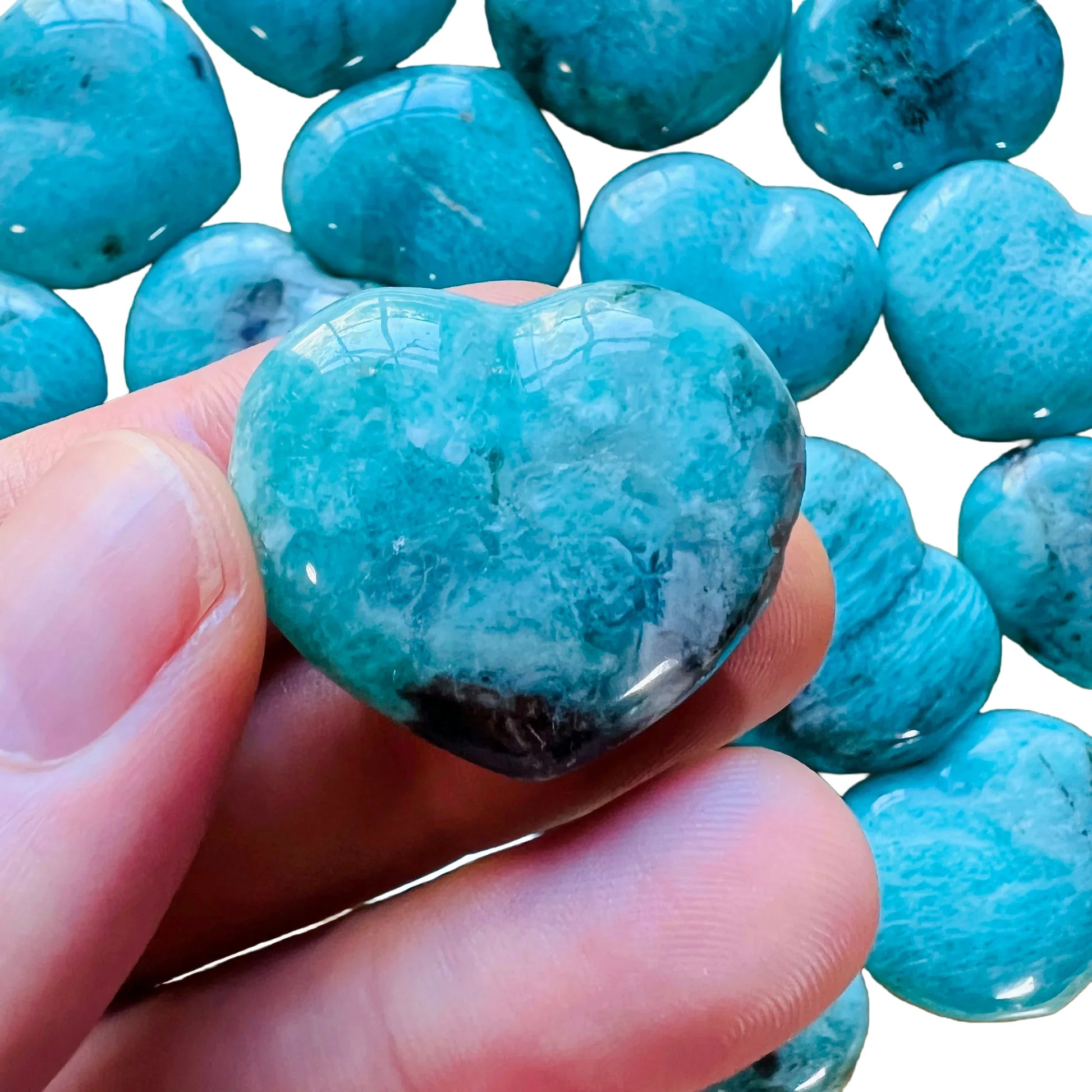 Natural light view of a Amazonite polished heart held against natural backdrop, Madagascar-sourced.