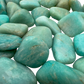 Macro shot of Amazonite tumbled stone, AA Grade, from Minas Gerais, Brazil, showing surface texture and natural inclusions.