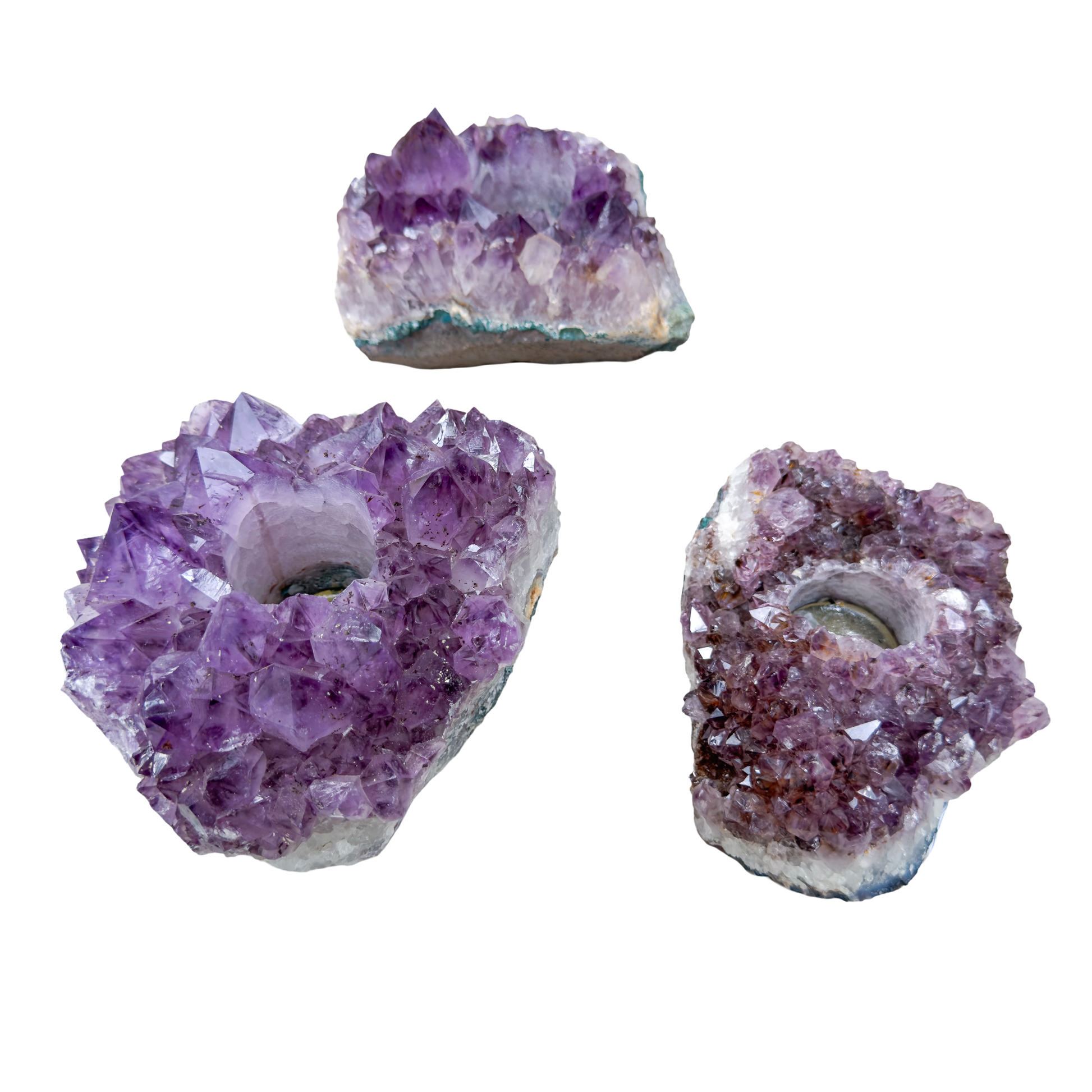 Amethyst candle holders grouped, showing variation in purple depth and crystal point size