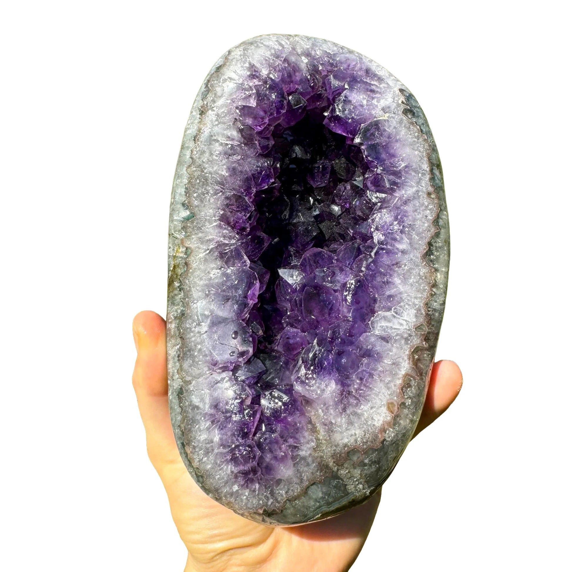 Grade aaa amethyst geode held in hand for size reference