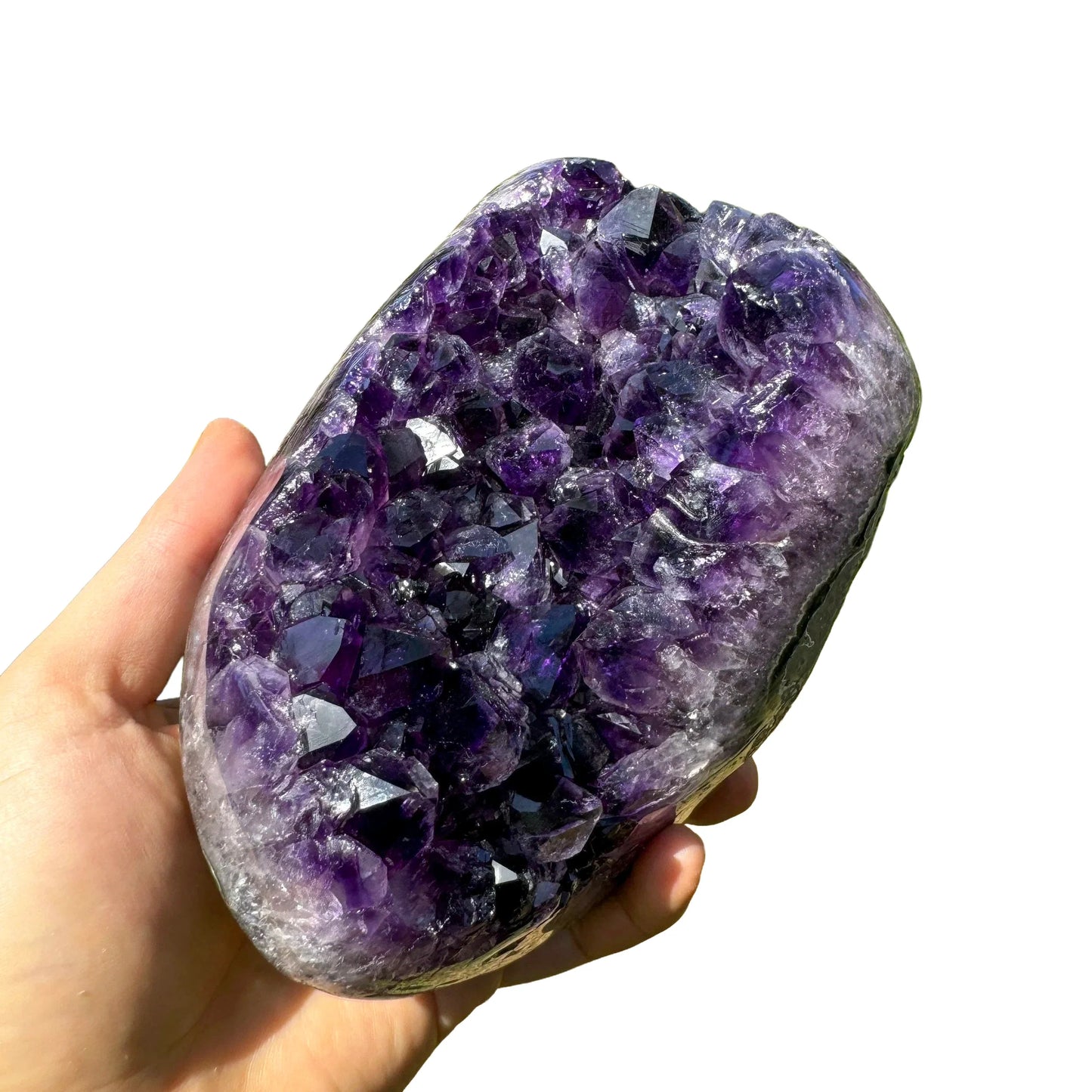 Grade aaa amethyst geode held in hand for size reference