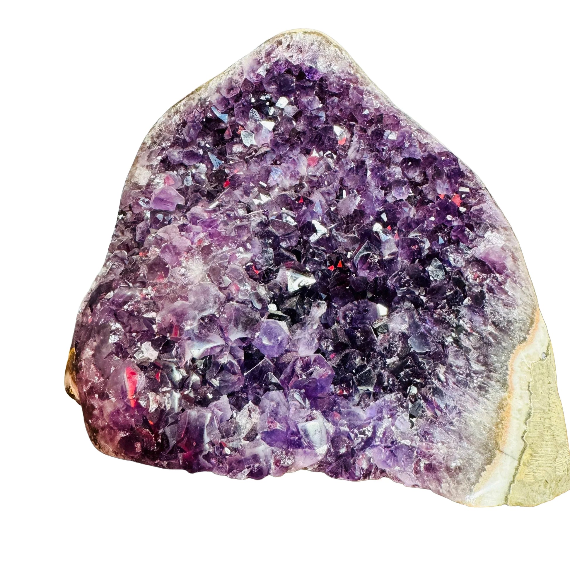 Palm-scale view of a Amethyst raw geode held against natural backdrop.