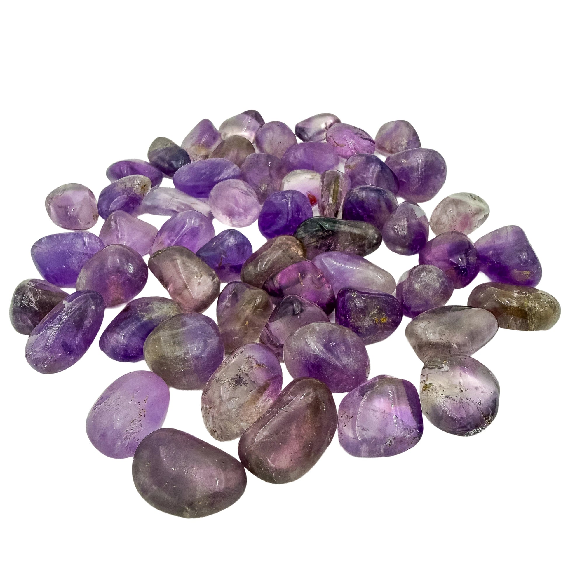 Low-angle view across a spread of small Amethyst tumbles showing depth of color