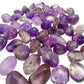 Loose scatter of small Amethyst tumbles showing color variation piece to piece