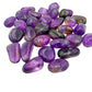 Angled view across Ametrine tumbles showing purple and gold zoning in each stone