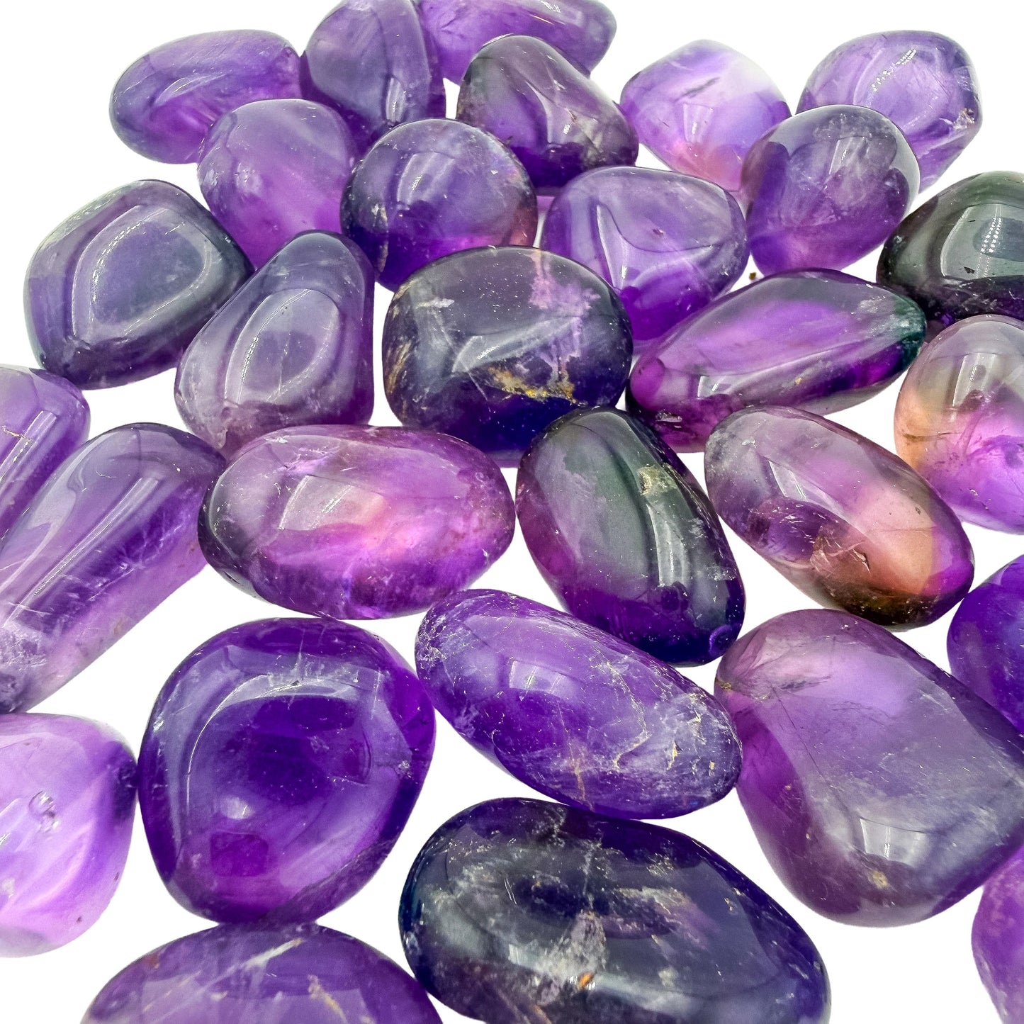 Overhead flat-lay of Bolivian Ametrine tumbled stones, 24 to 40 pieces a pound