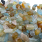 Holding an Aquamarine stone, from Huila, Angola, shown in a calm studio setting.