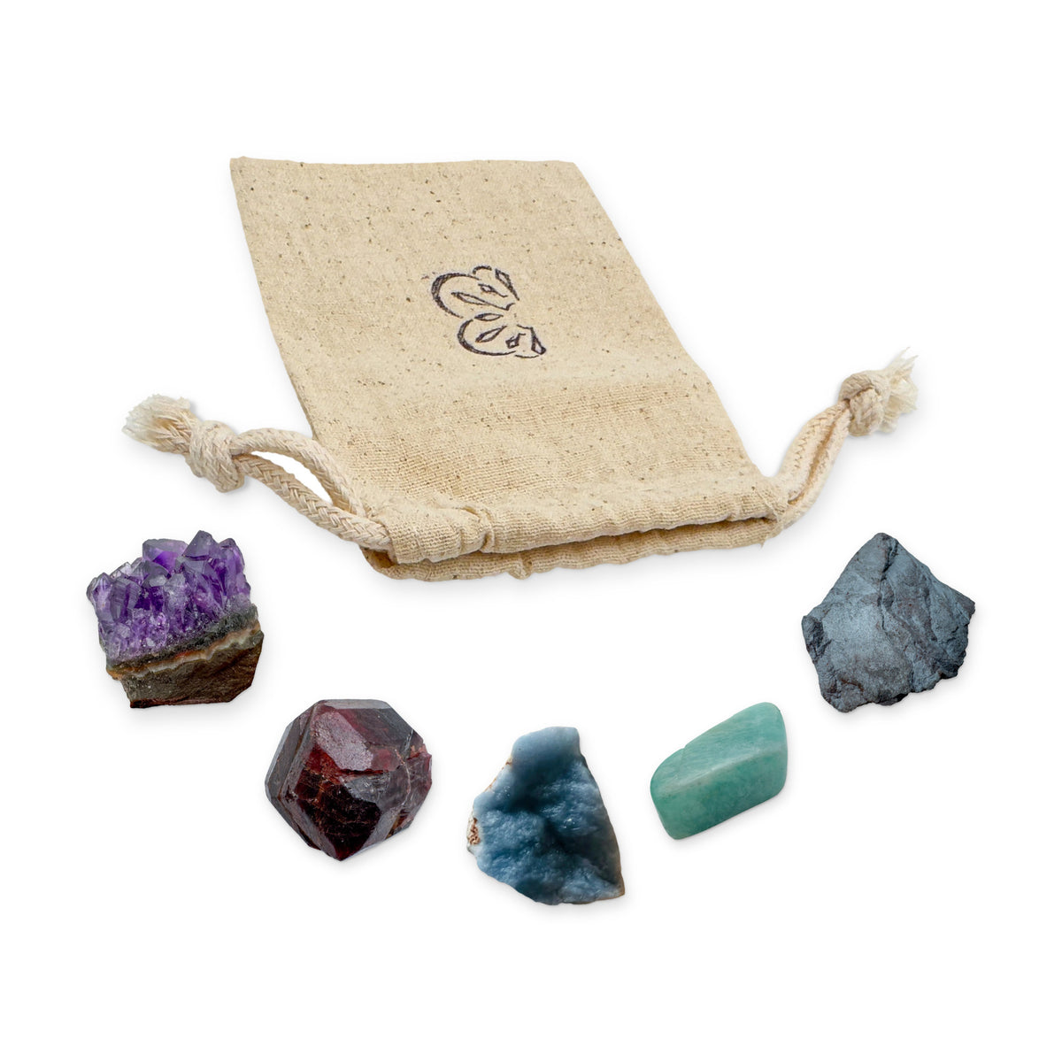Aquarius Crystal Kit: amethyst cluster, garnet, angelite, amazonite and hematite, arranged with the reusable cotton bag they come in, on white
