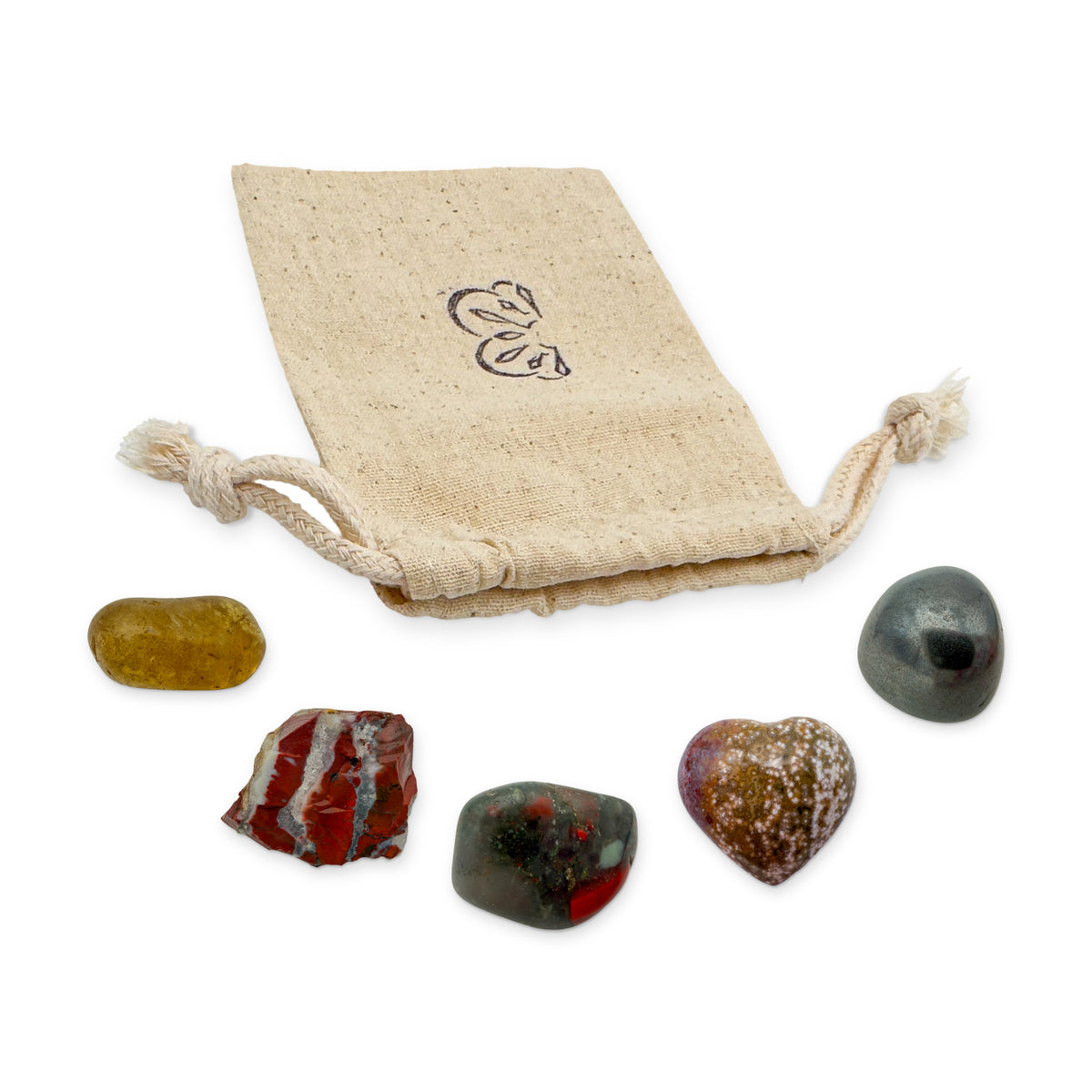 Aries Crystal Kit: natural citrine, red jasper, bloodstone, ocean jasper heart and hematite, arranged with the reusable cotton bag they come in, on white