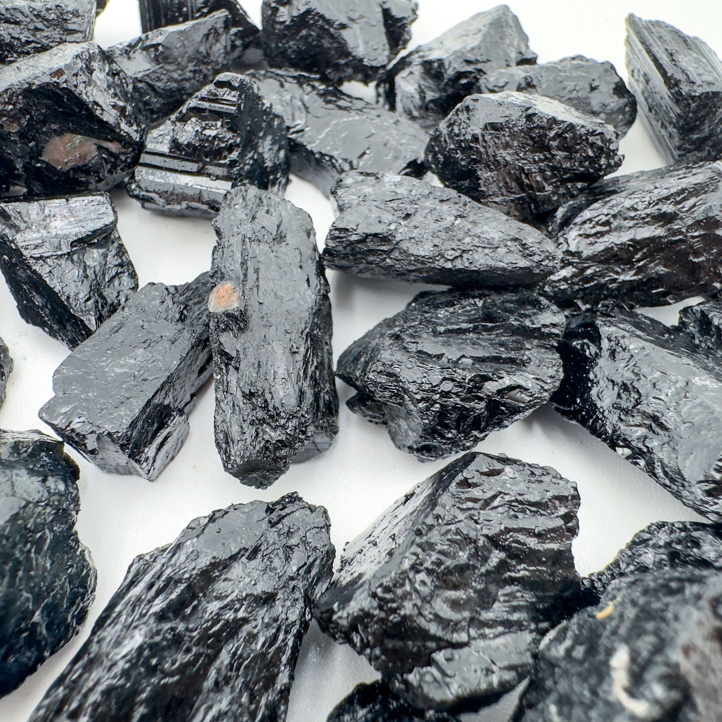 Hand-scale shot of a Black Tourmaline raw stone, sourced from Brazil.