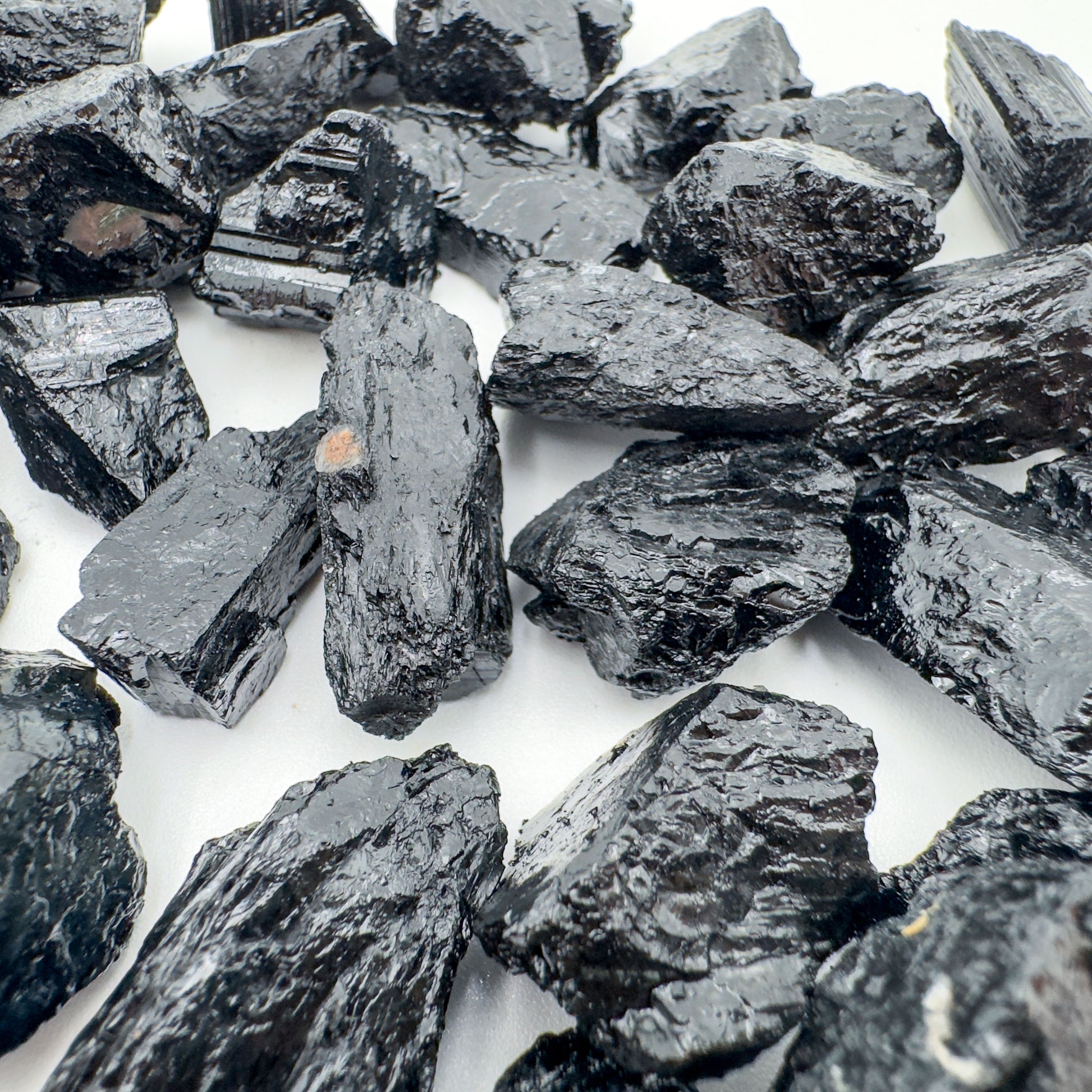 Hand-scale shot of a Black Tourmaline raw stone, sourced from Brazil.