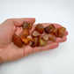 Held in hand, a Carnelian raw stone, from Brazil.