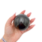 Black Jade sphere no. 4 held in an open hand, showing the true scale of this 2.81 inch, 530 gram orb.