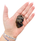 Raw black tourmaline specimen from Madagascar held in hand to show scale