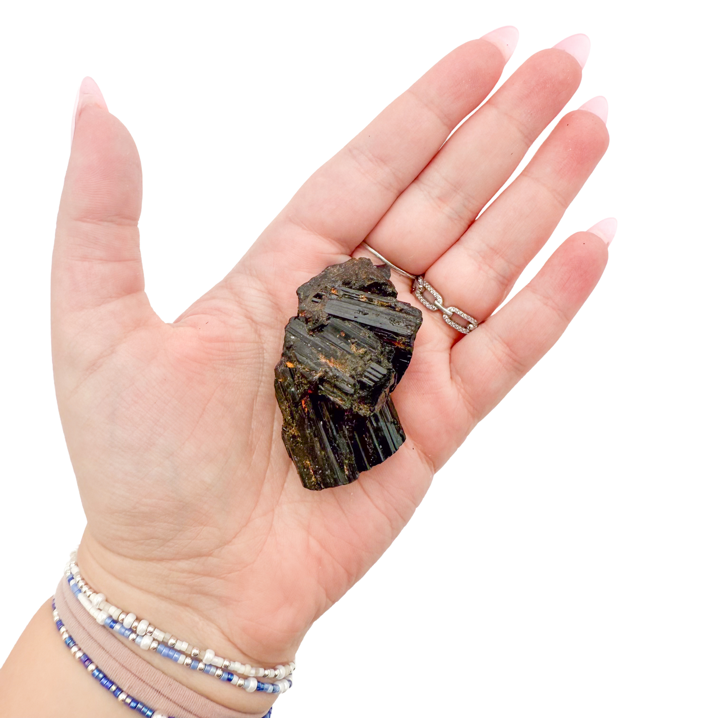 Raw black tourmaline specimen from Madagascar held in hand to show scale