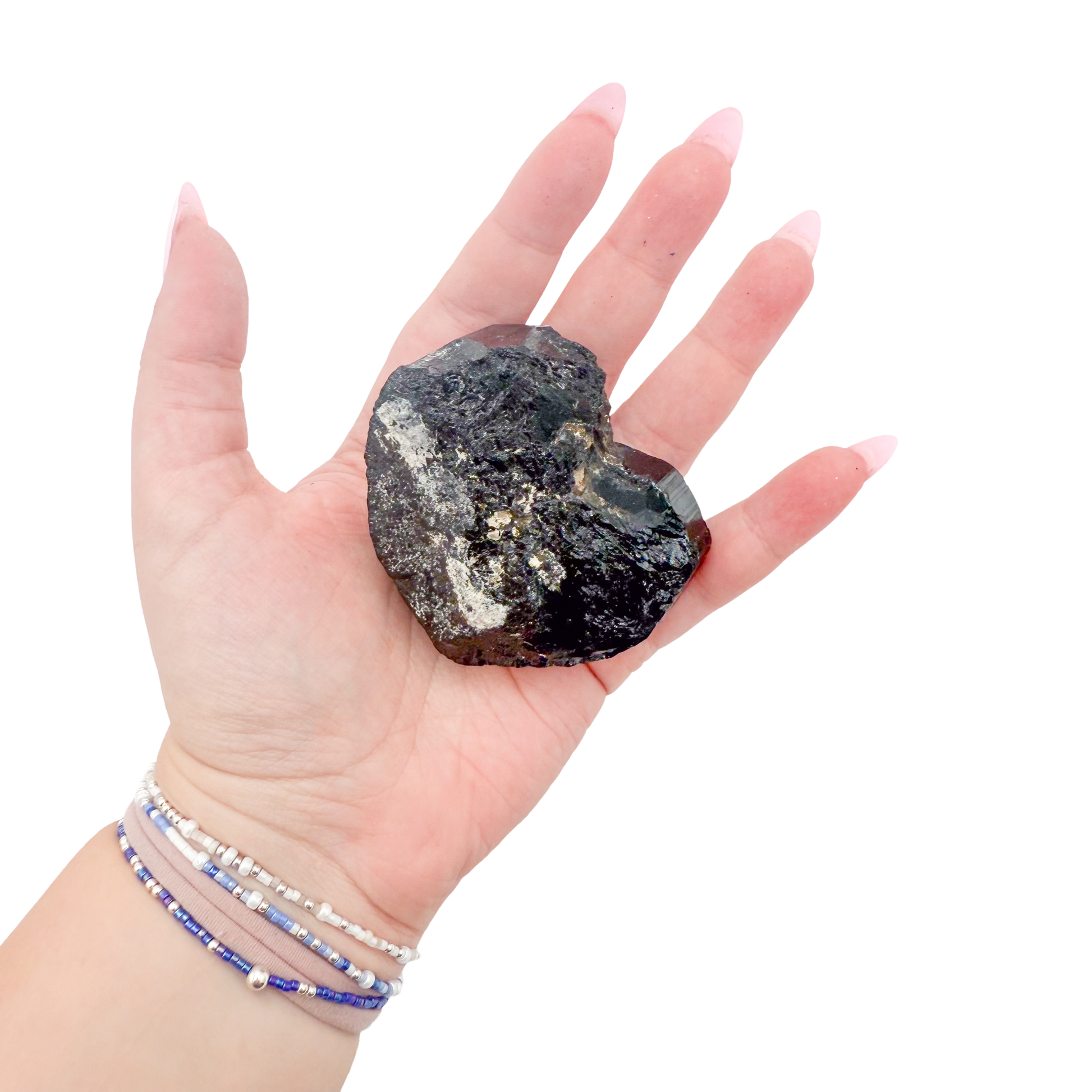 Raw black tourmaline specimen from Madagascar held in hand to show scale