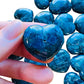 Hand-scale shot of one Apatite polished heart for scale, from Anosy, Madagascar.