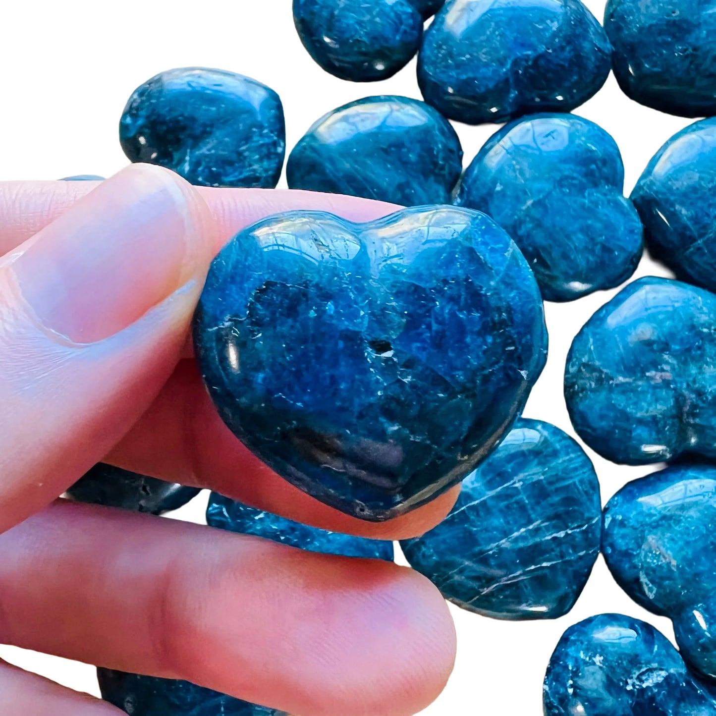 Hand-scale shot of one Apatite polished heart for scale, from Anosy, Madagascar.