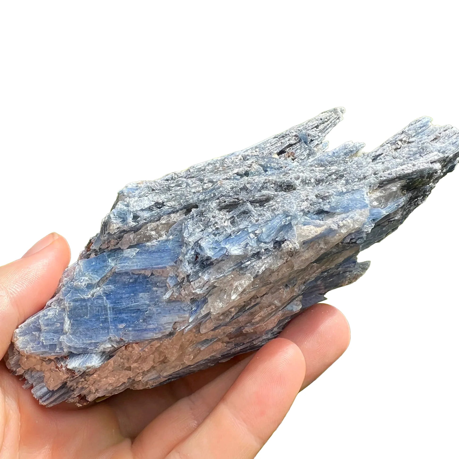 Set against a soft backdrop is a Blue Kyanite specimen, from Minas Gerais, Brazil, traditionally used for Intuition, shown for proportion against the hand.