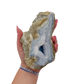 Blue lace agate raw geode held in hand to show scale