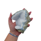Blue lace agate raw geode held in hand to show scale