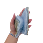 Blue lace agate raw geode held in hand to show scale