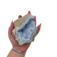 Blue lace agate raw geode held in hand to show scale