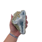 Blue lace agate raw geode held in hand to show scale