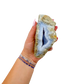 Blue lace agate raw geode held in hand to show scale