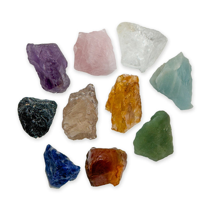 Large Brazilian raw crystal set: ten rough stones including amethyst, rose quartz, clear quartz, black tourmaline and sodalite, together on white