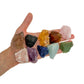 Ten large rough Brazilian crystals held in an open hand for scale