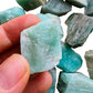 Grade a amazonite raw held in hand for size reference