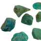 Hand-scale shot of a Amazonite raw stone held against natural backdrop, from Mozambique.