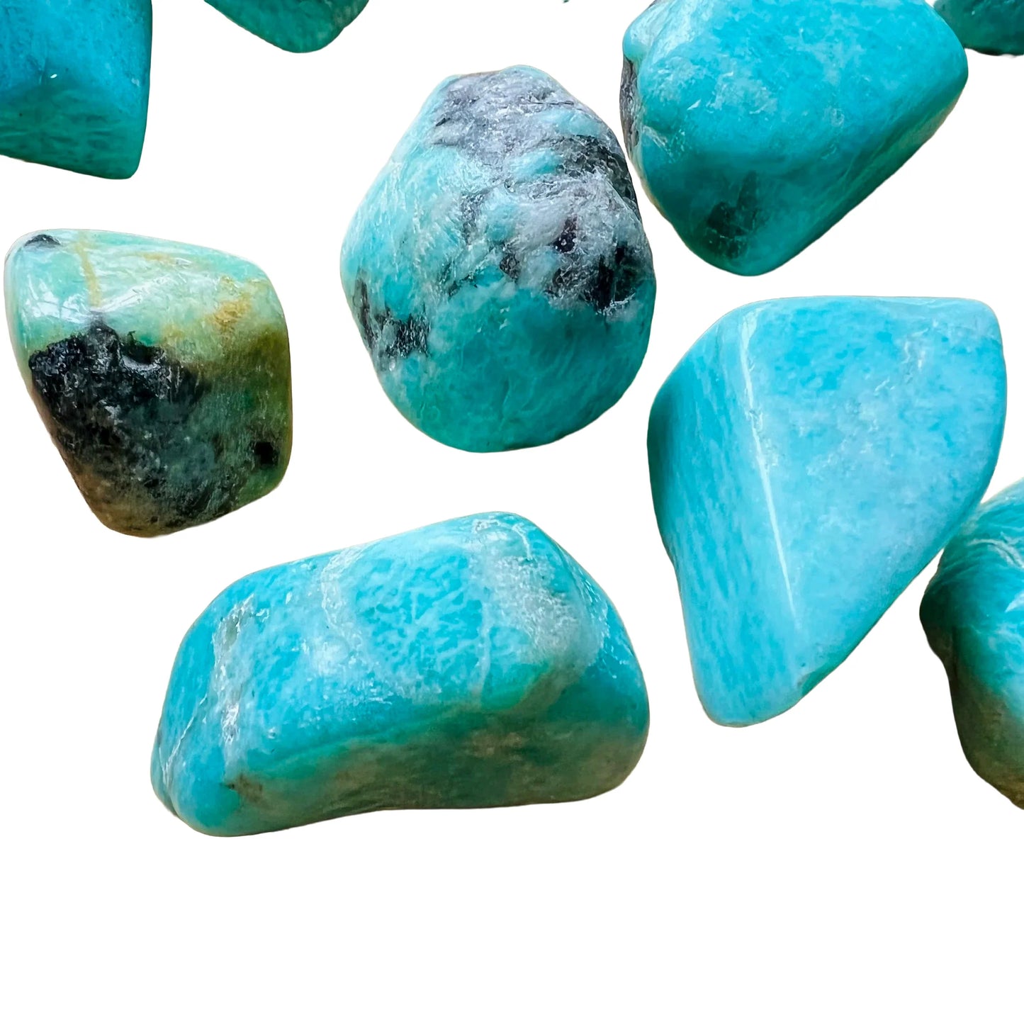 Lifestyle view of a Amazonite tumbled stone held against natural backdrop, sourced from Madagascar.