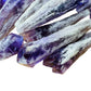 Hand-scale shot of a Amethyst raw point held against natural backdrop, sourced from Bahia, Brazil.