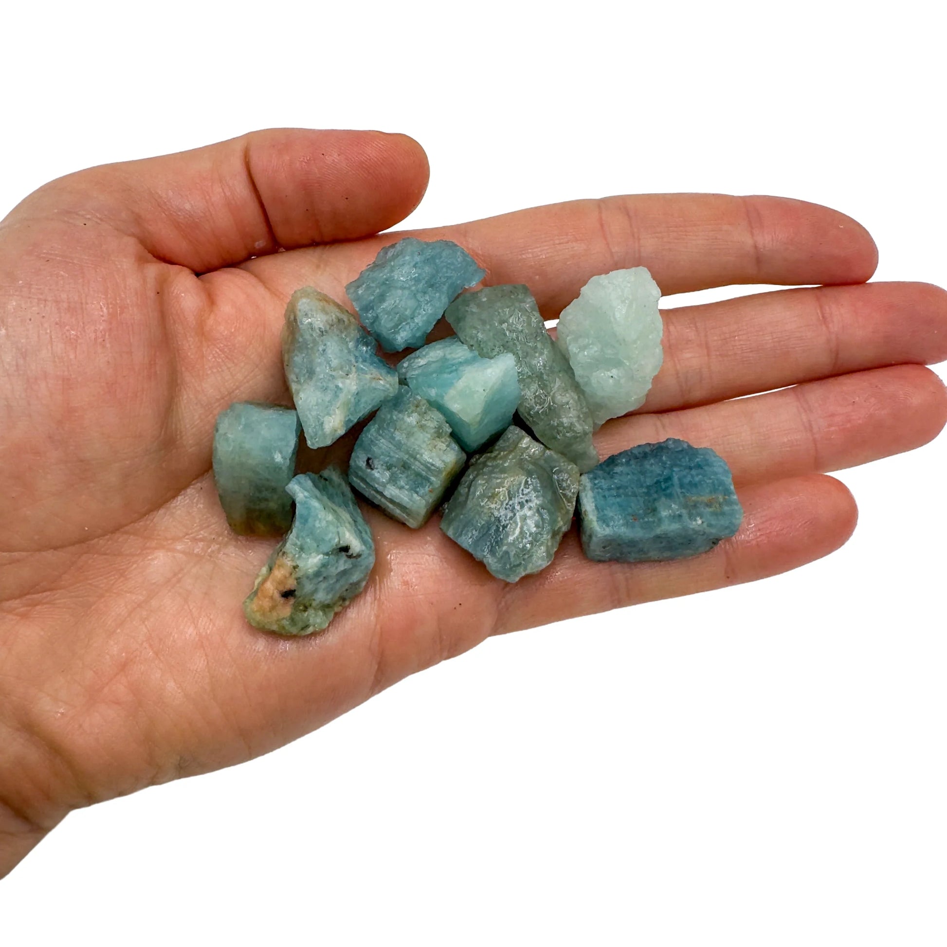 Hand holding small aquamarine raw crystals 5-10 grams Brazil scale reference