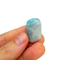 Hand-scale shot of a Aquamarine tumbled stone often kept for Stress Relief.