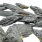 Grade a black kyanite raw held in hand for size reference