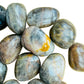 Magnified detail of Grade AA Black Moonstone tumbled stone, showing subtle veining.