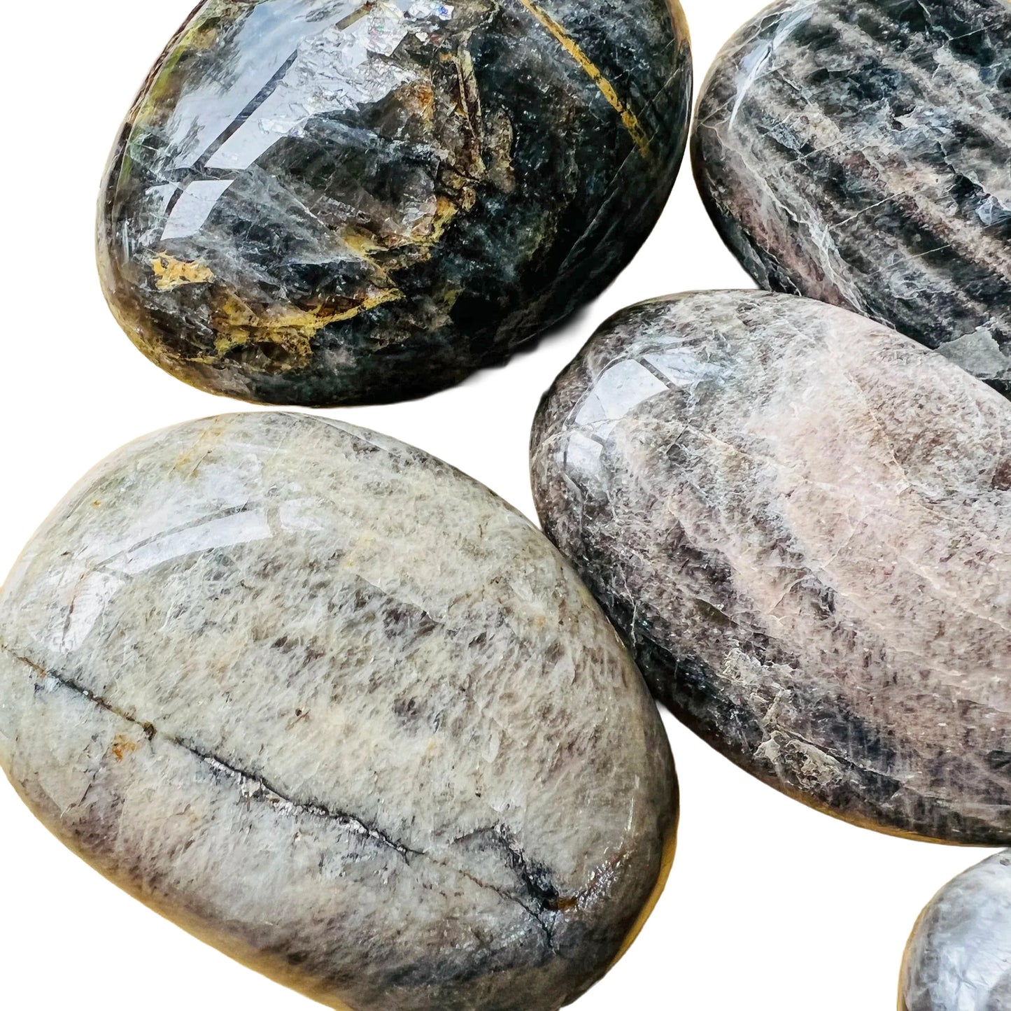 Side-on view of Black Moonstone palm stone, Madagascar-sourced, showing natural inclusions.