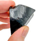 Palm-scale view of a single Black Obsidian raw stone sourced from Argentina.