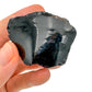 Grade aa black obsidian raw held in hand for size reference