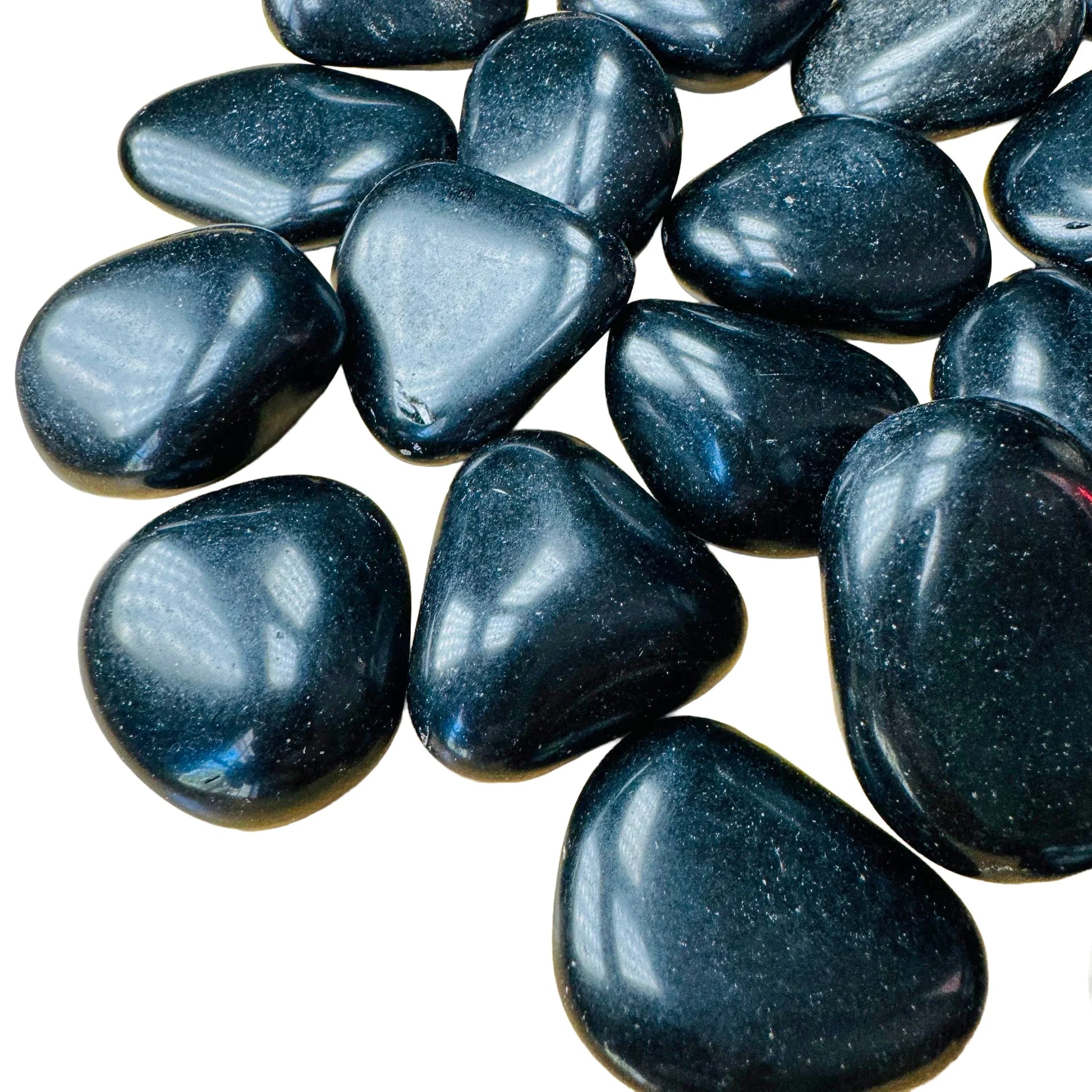 Edge-on view of Grade AA Black Obsidian tumbled stone, sourced from Argentina, showing characteristic finish.