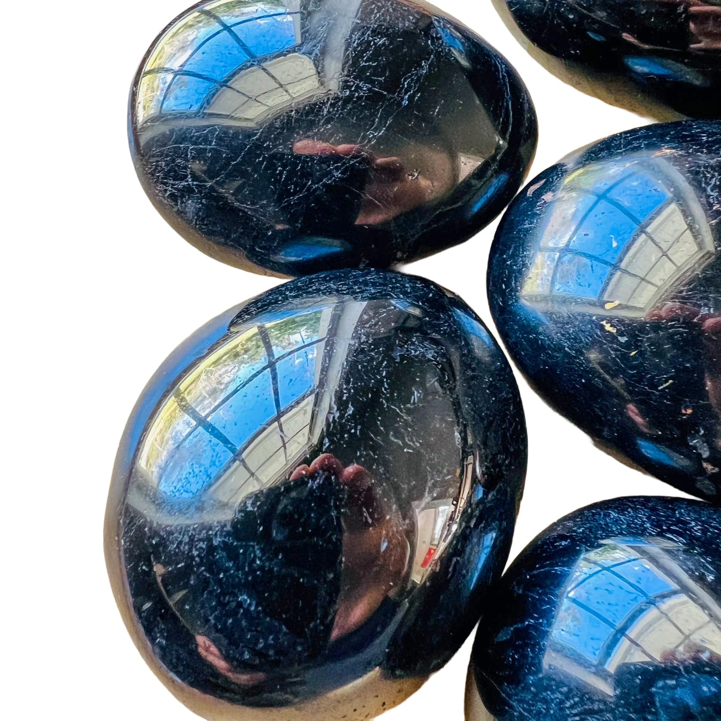 Close-up of Black Tourmaline palm stone, showing natural texture.