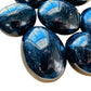 Edge-on view of Black Tourmaline palm stone, showing characteristic color.