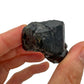 Grade aa black tourmaline raw held in hand for size reference