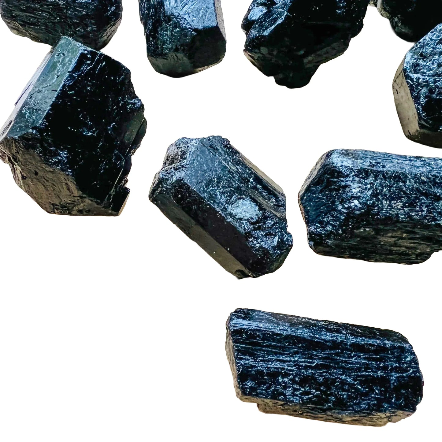 Natural light view of a Black Tourmaline raw stone held against natural backdrop, from Vakinankaratra, Madagascar.