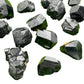 Hand-scale shot of a Black Tourmaline raw stone held against natural backdrop.
